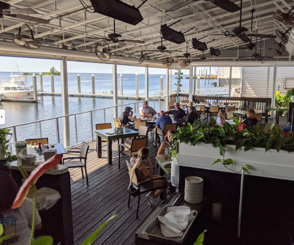 Hula Bay Club Restaurant view of water-side seating with patrons sprinkled throughout